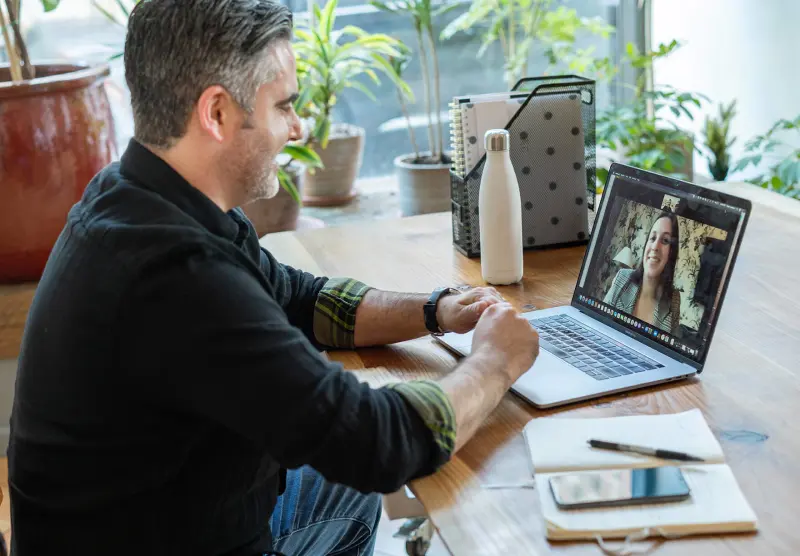 Remote video call interview between a smiling independent contractor and a hiring manager on laptop screen