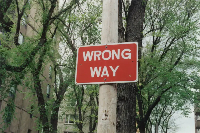 A wrong way sign among trees tells you to consider your approach!