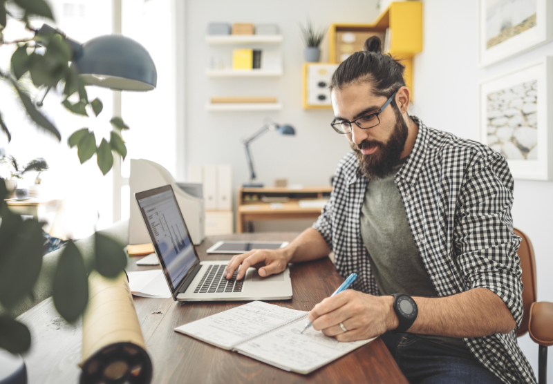 A man working at his desk with a laptop.